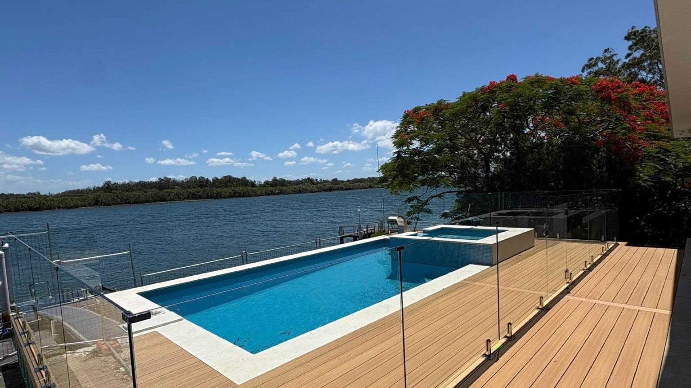 A finished timber deck and pool overlooking the water