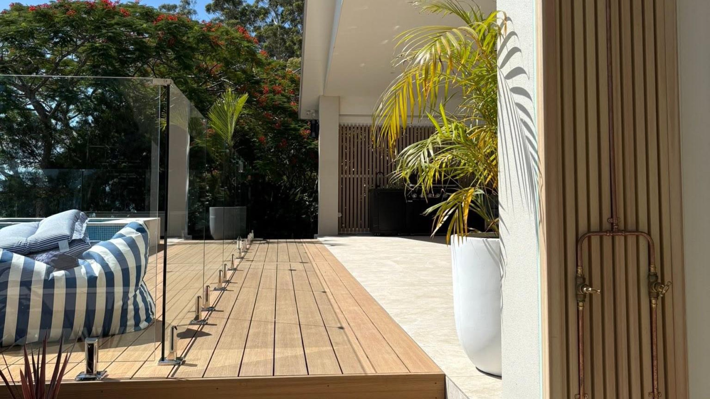 A covered outdoor deck and entertaining area beside a pool